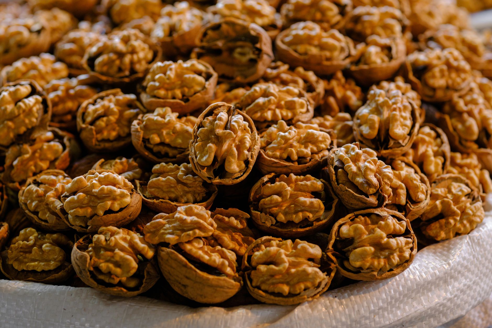 A detailed close-up photo showcasing a pile of fresh organic walnuts in shells, perfect for healt... (Photo by Engin Akyurt on Pexels)