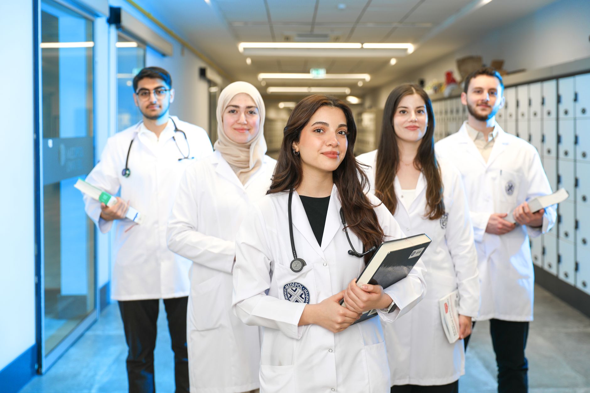 Group of diverse medical students wearing lab coats in university corridor, representing future h... (Photo by Yusuf Çelik on Pexels)