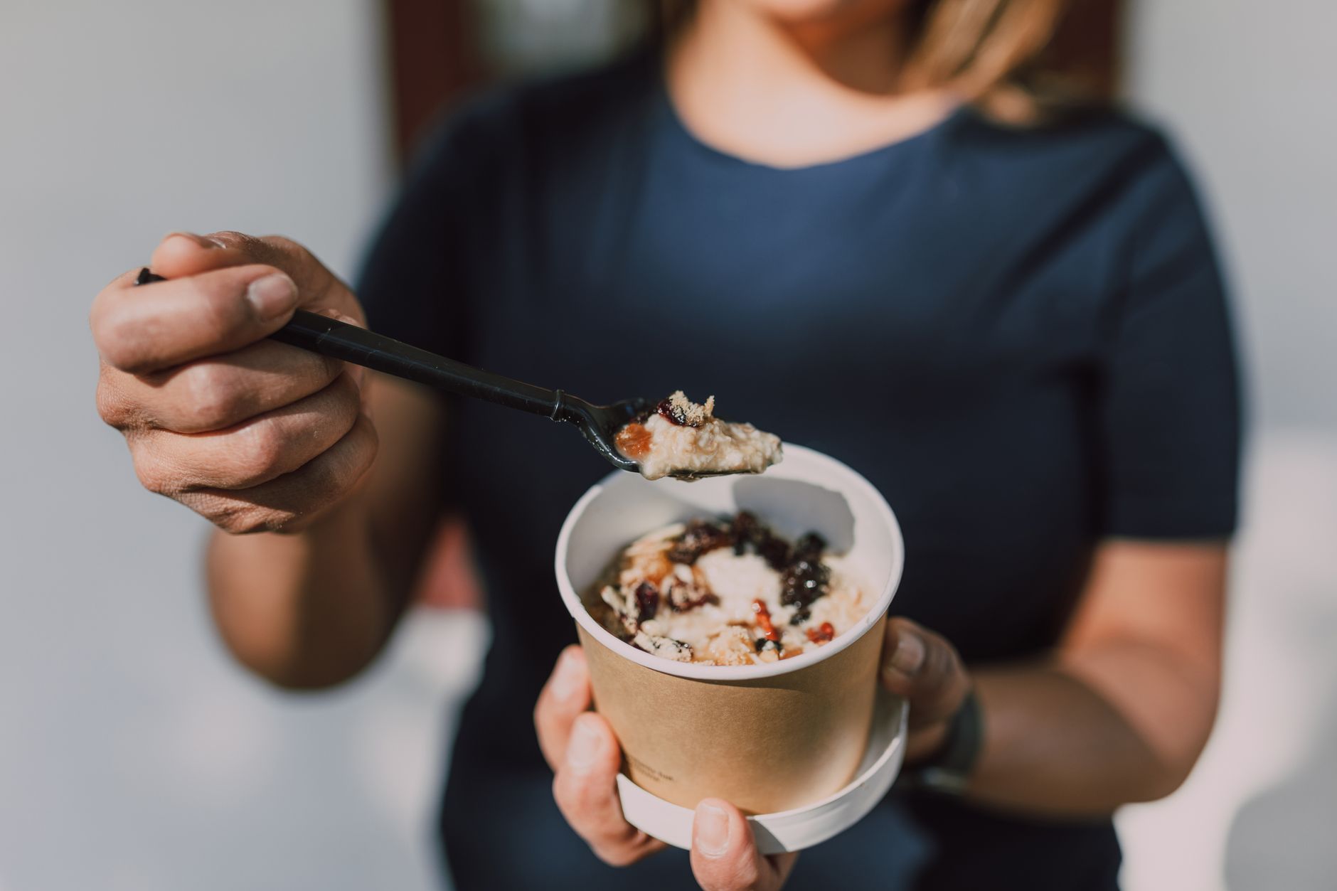 Close-up of a person holding a bowl of vegan oatmeal topped with fruits. (Photo by RDNE Stock project on Pexels)
